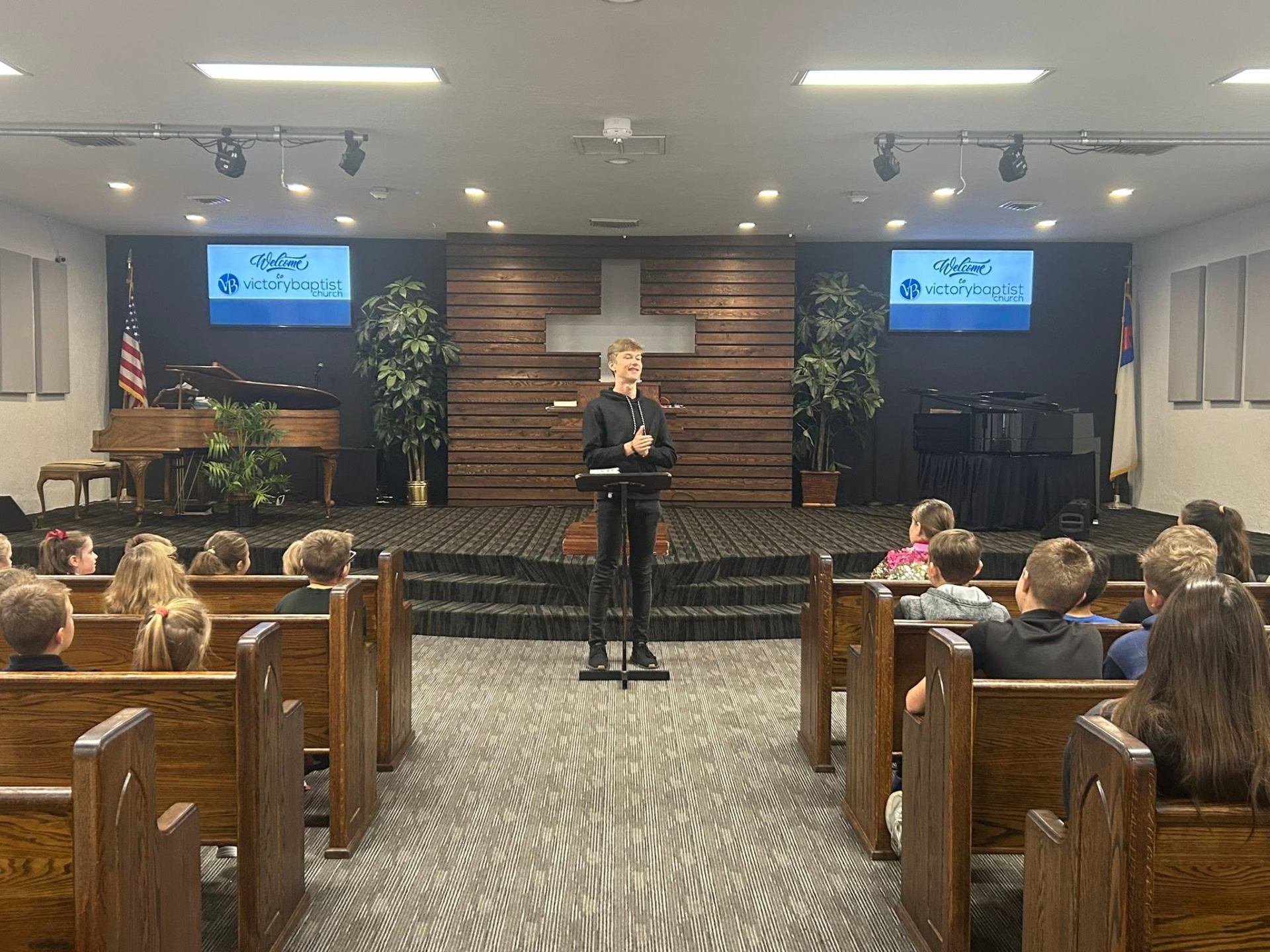 A student leading chapel service at Victory Baptist Academy
