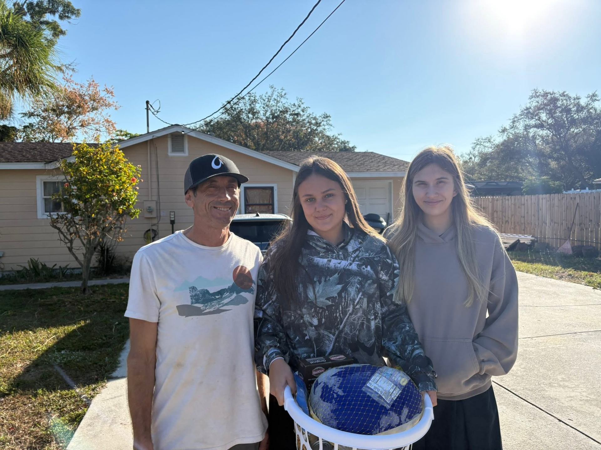 VBA students with a family receiving a Thanksgiving basket